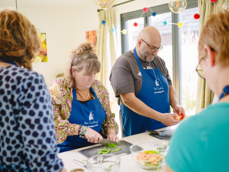 A couple cooking together at a cooking class.